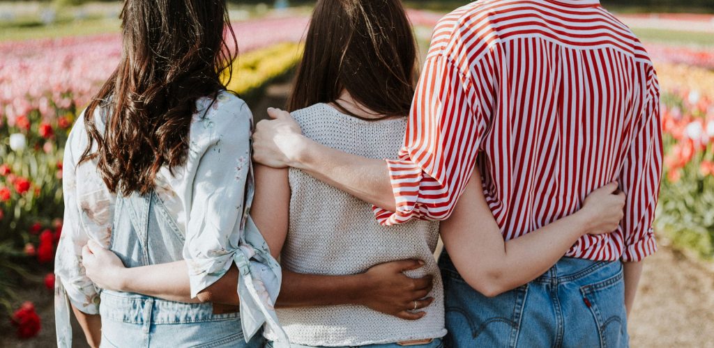 women with arms around